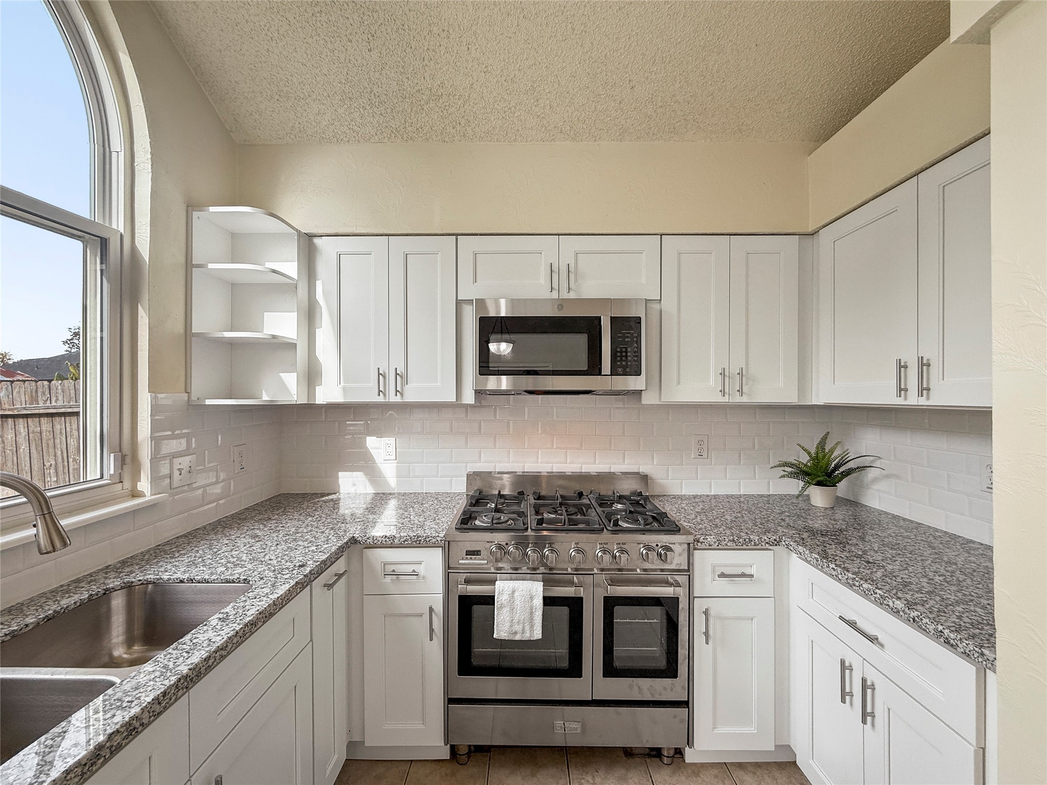 13635 Repa Lane Houston, TX 77014 - Photo 21 of 50 A large window offers natural light, complemented by a sleek subway tile backsplash.