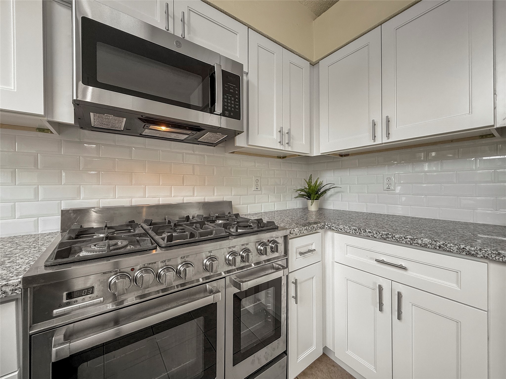 13635 Repa Lane Houston, TX 77014 - Photo 21 of 49 The white cabinetry, granite countertops, and a classic subway tile backsplash generates a clean, contemporary look.