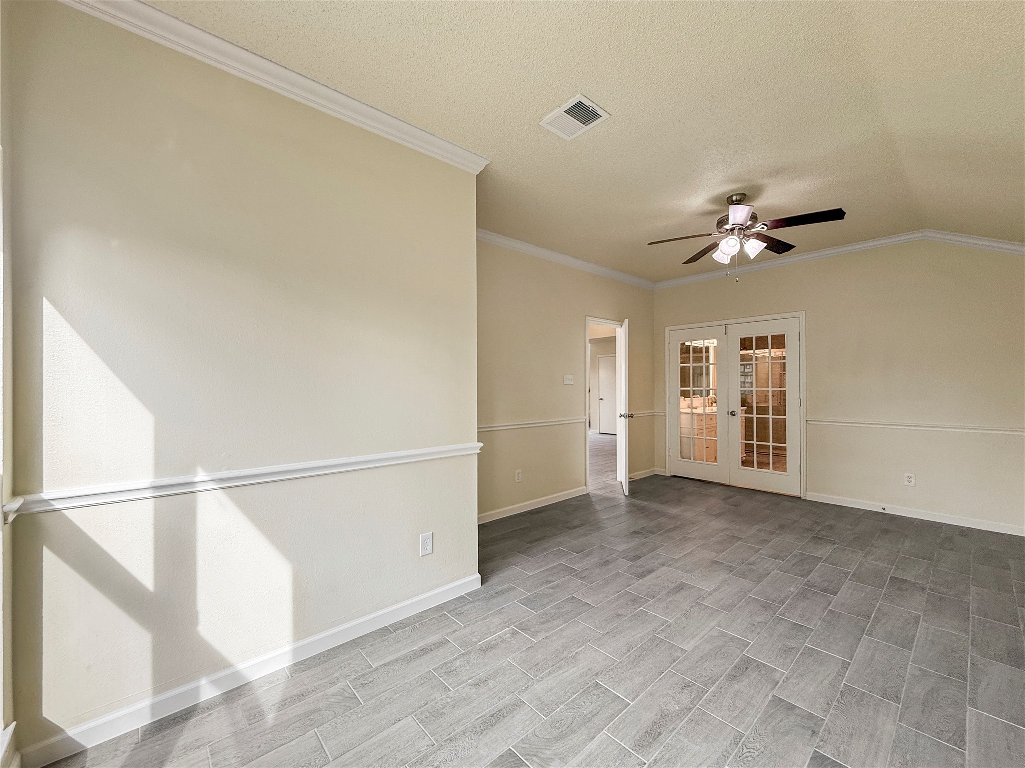 13635 Repa Lane Houston, TX 77014 - Photo 29 of 50 The primary bedroom is bright, with neutral walls and tile flooring, and features, crown molding, a ceiling fan and French doors leading to the primary bathroom.