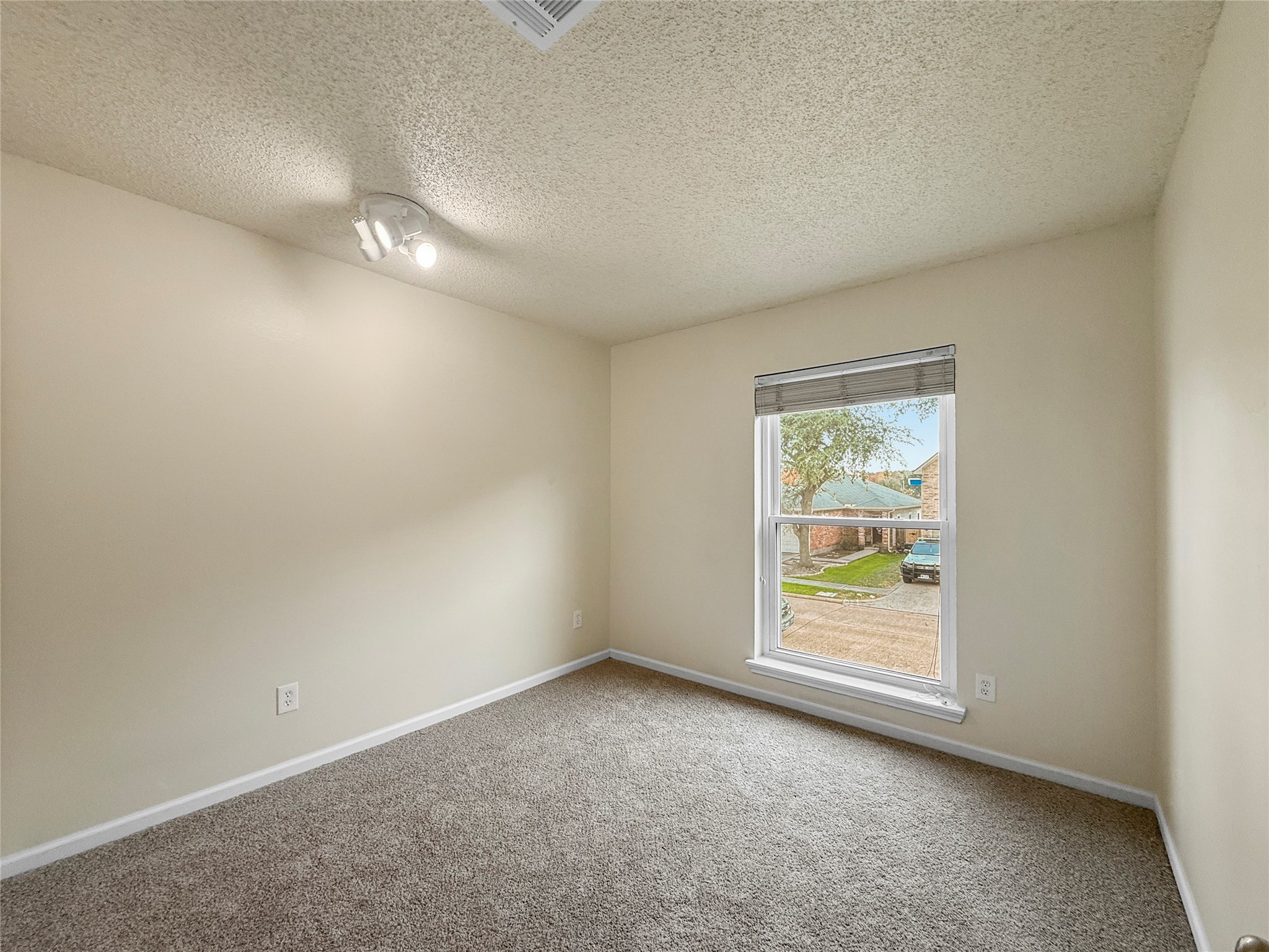13635 Repa Lane Houston, TX 77014 - Photo 37 of 50 This is a bright, cozy bedroom featuring neutral walls and carpeted flooring. It has a large window offering a view of the street, and a ceiling light fixture for ample lighting.