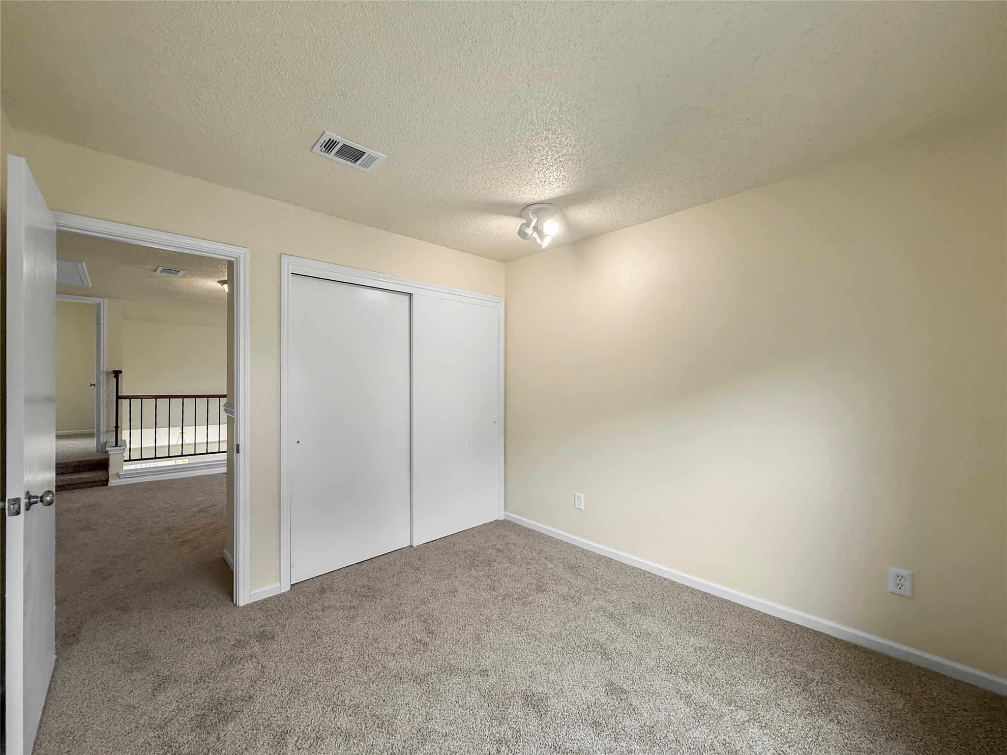 13635 Repa Lane Houston, TX 77014 - Photo 38 of 49 Here's another view of the same bedroom showing the door to the hallway and the closet with sliding doors.