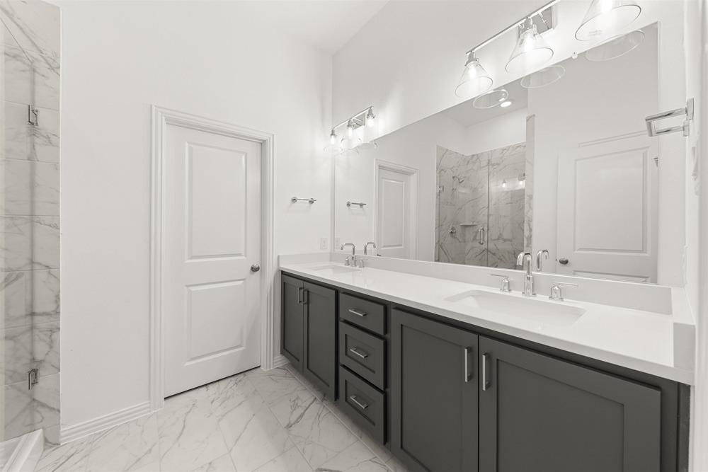 1237 Doris May Drive Allen, TX 75013 - Photo 17 of 19 Contemporary bath featuring a double vanity with dark cabinetry and light countertops