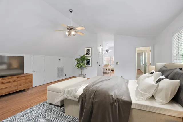 a bedroom with a bed chandelier and a window