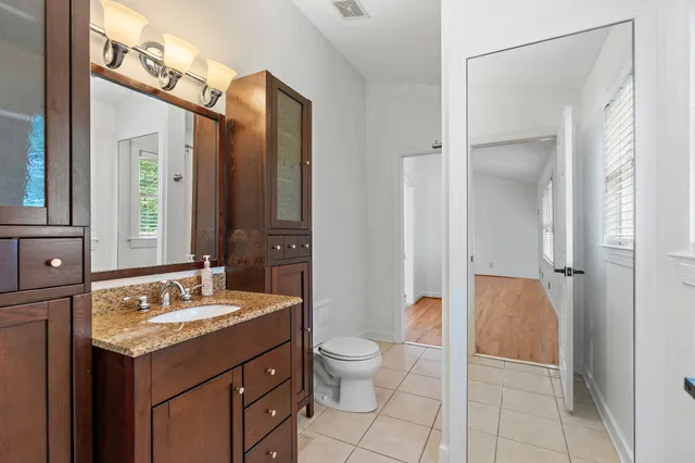 a bathroom with a granite countertop sink toilet and shower
