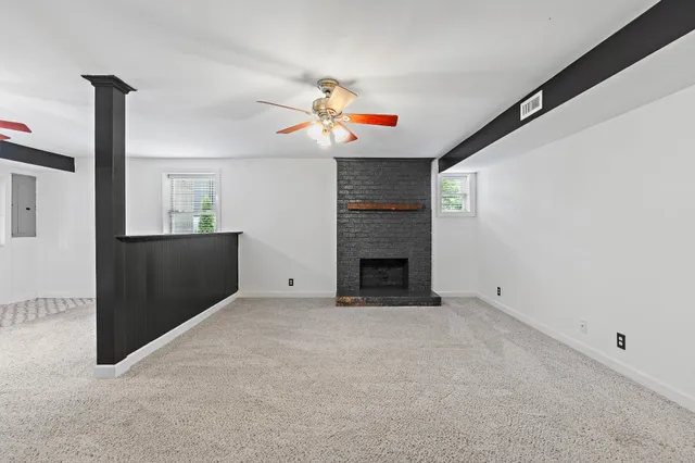 an empty room with fireplace and chandelier