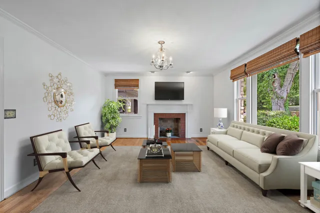 a living room with furniture fireplace and a large window