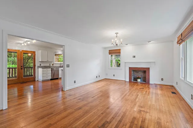 wooden floor fireplace and windows in an empty room