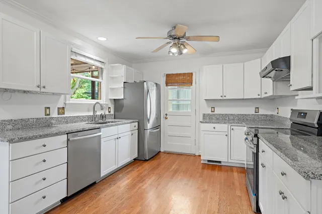a kitchen with granite countertop appliances cabinets and a sink