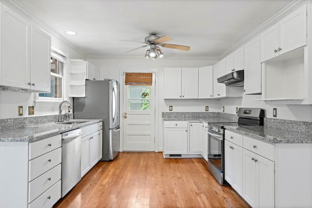 a kitchen with a sink a refrigerator and white cabinets