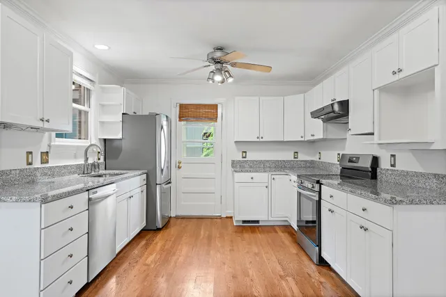 a kitchen with a sink a refrigerator and white cabinets