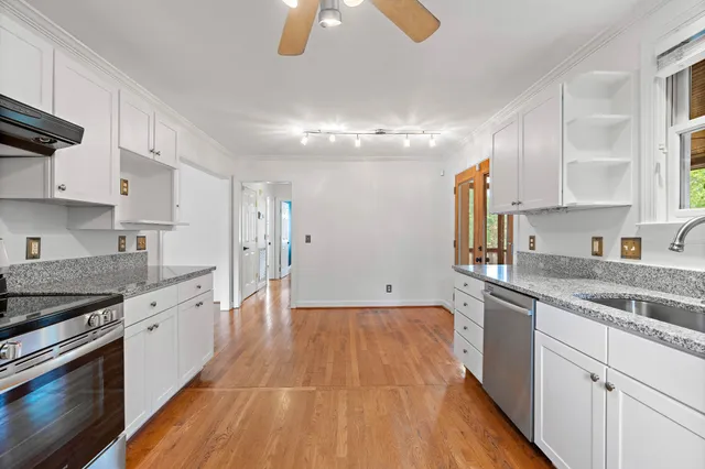 a large kitchen with cabinets wooden floor and stainless steel appliances