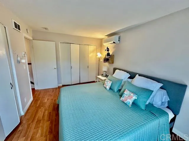 a bedroom with a bed and a flat tv screen on the dresser