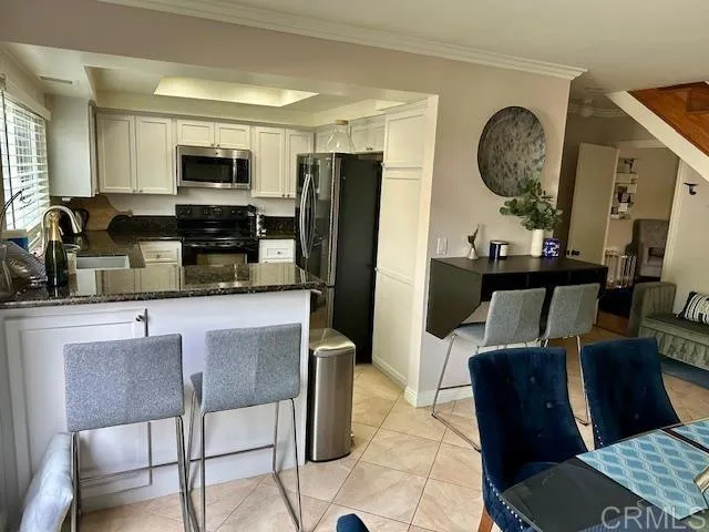 a view of a livingroom and dining room with furniture wooden floor and a chandelier