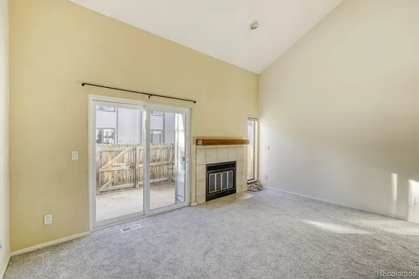 a view of an empty room with a fireplace and a window