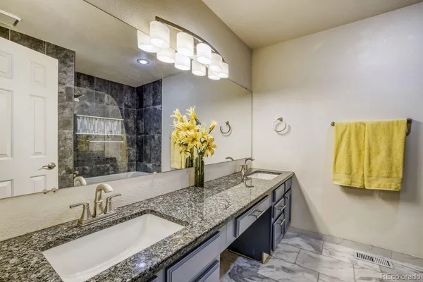 a bathroom with a granite countertop sink and a mirror