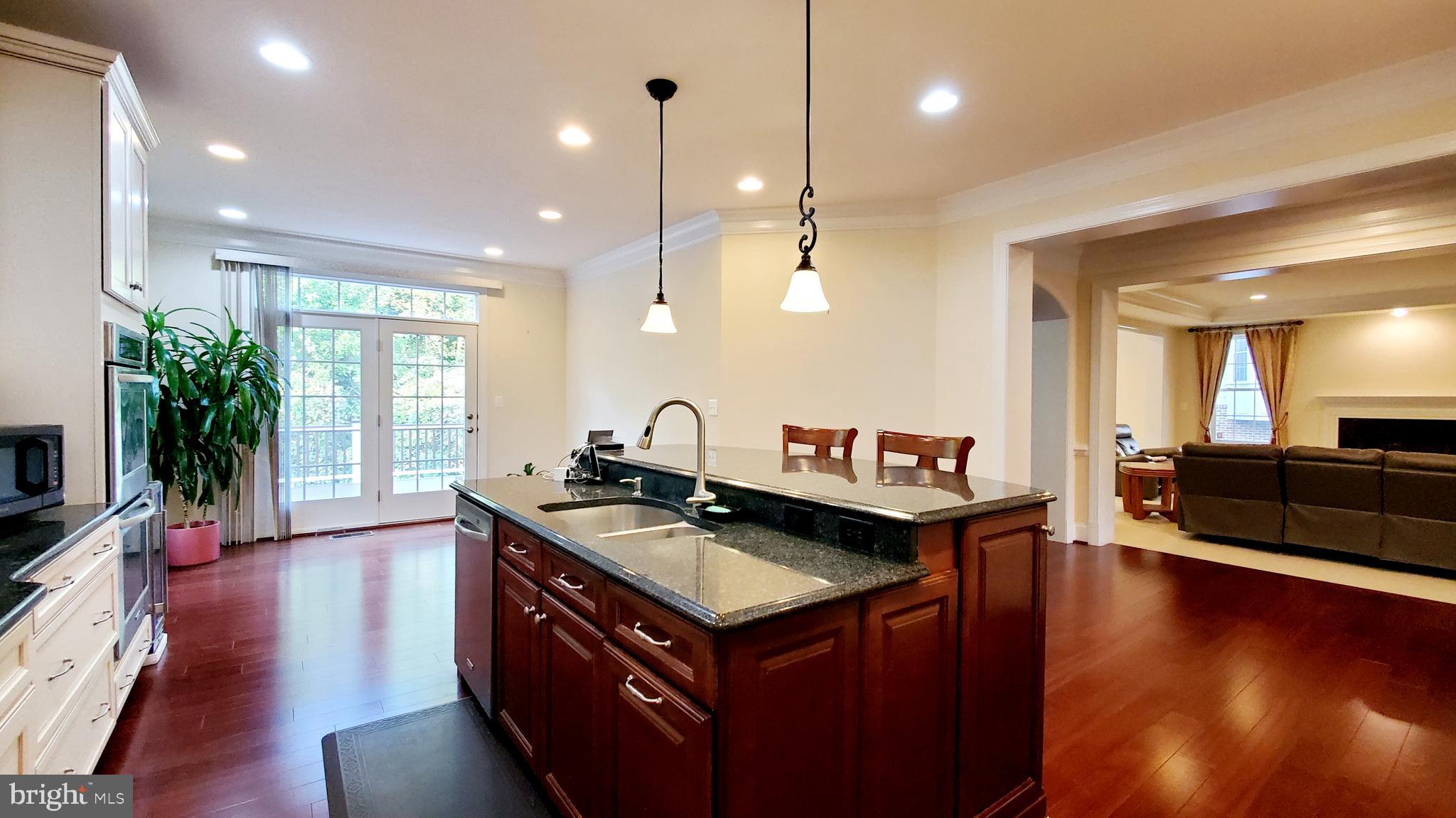 12614 Winter Wren Court Herndon, VA 20171 - Photo 14 of 55 a kitchen that has a lot of cabinets a sink and wooden floor