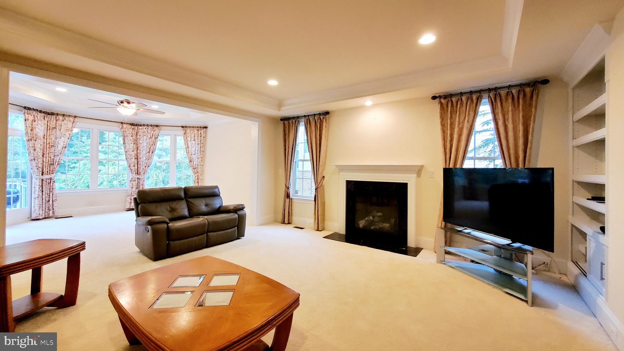 12614 Winter Wren Court Herndon, VA 20171 - Photo 20 of 55 a living room with furniture a flat screen tv and a fireplace