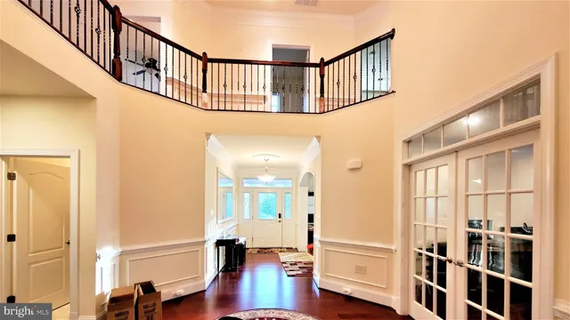 a view of a hallway to a livingroom with wooden floor and furniture