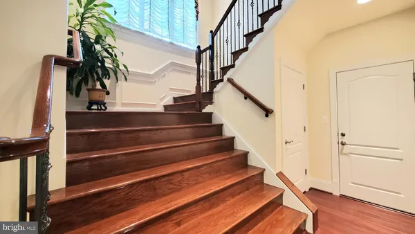 a view of a hallway with wooden floor and a living room