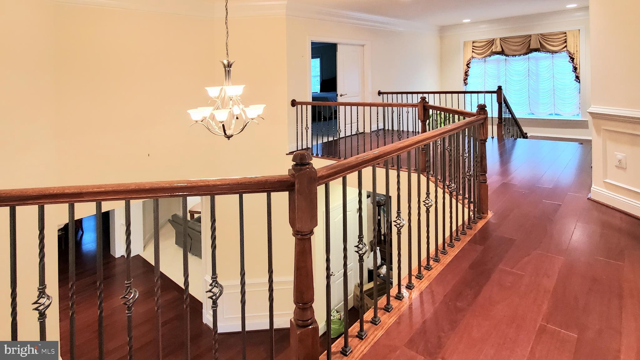 12614 Winter Wren Court Herndon, VA 20171 - Photo 27 of 55 a view of a hallway with wooden floor and stairs