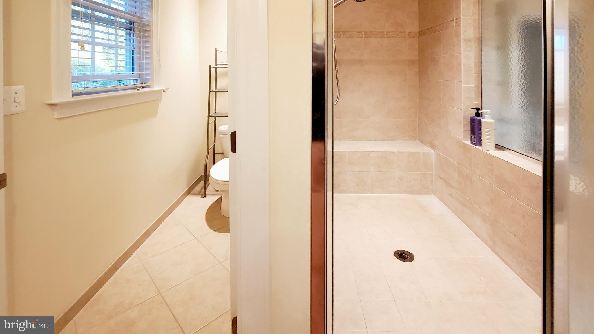 12614 Winter Wren Court Herndon, VA 20171 - Photo 36 of 55 a bathroom with a glass shower door