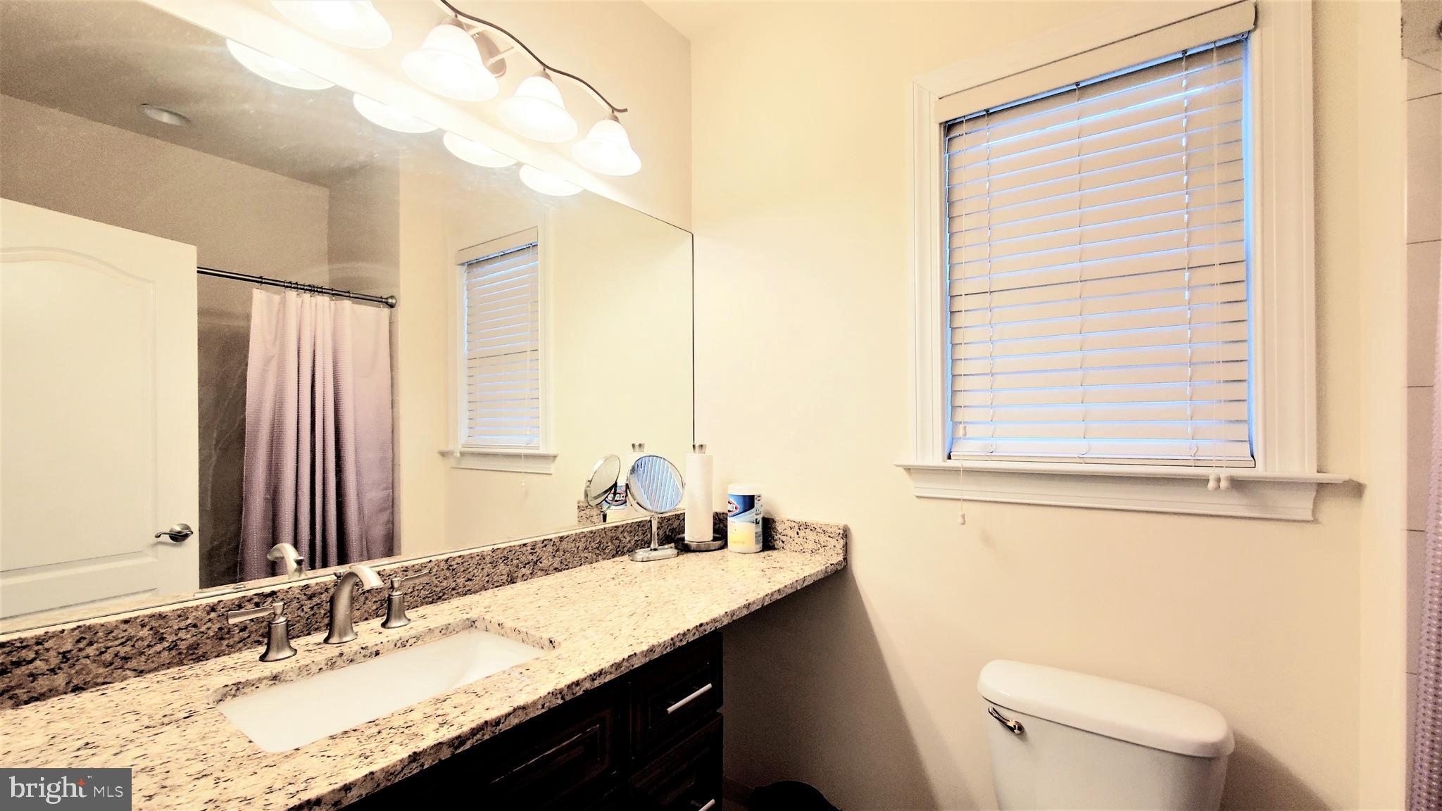 12614 Winter Wren Court Herndon, VA 20171 - Photo 46 of 55 a bathroom with a granite countertop sink a toilet and a mirror