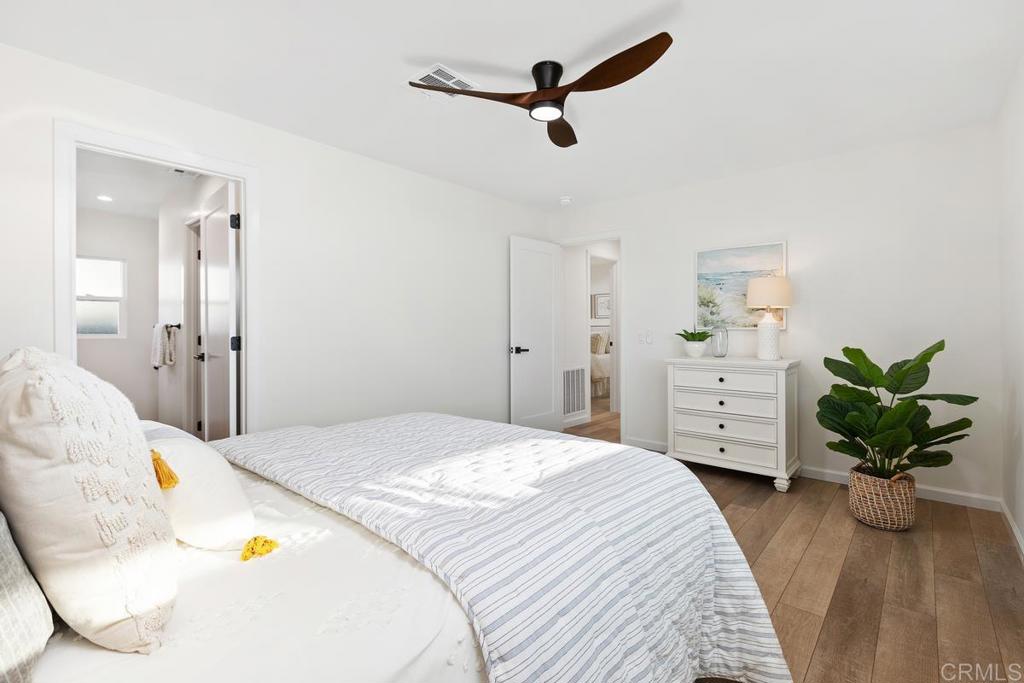 7144 Santa Rosa Carlsbad, CA 92011 - Photo 22 of 41 a bedroom with a bed dresser and a living room
