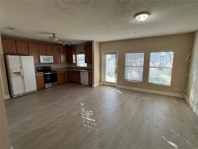 an empty room with a kitchen view and a window
