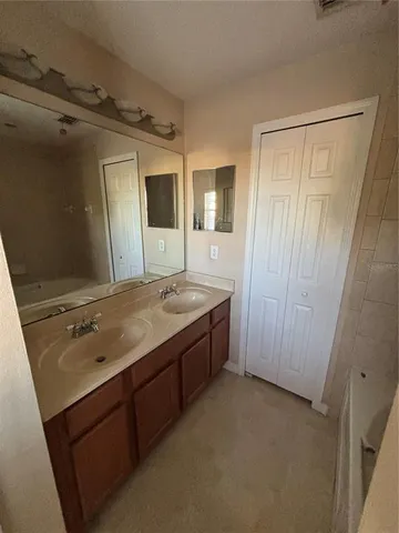 a bathroom with a granite countertop sink a mirror and a bathtub