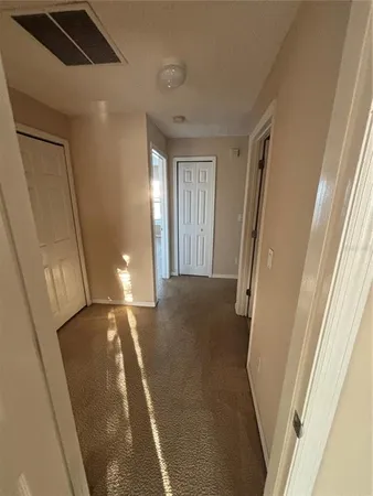 a view of a hallway to a livingroom with furniture