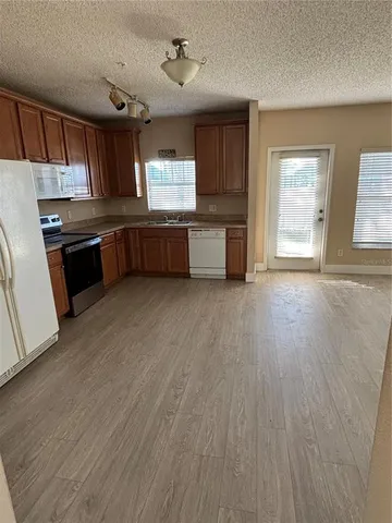 a kitchen with stainless steel appliances wooden floors and wooden cabinets
