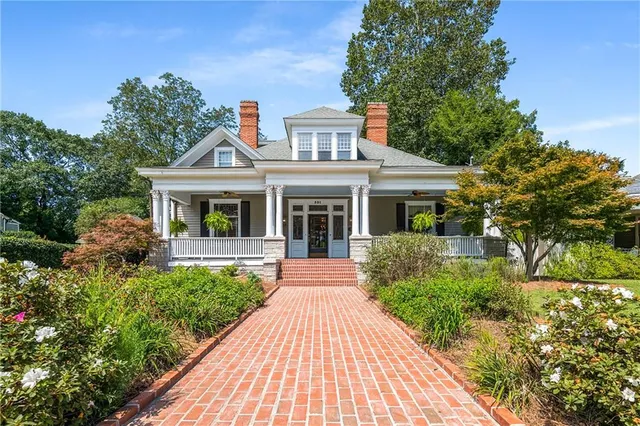 a front view of a house with a yard and potted plants