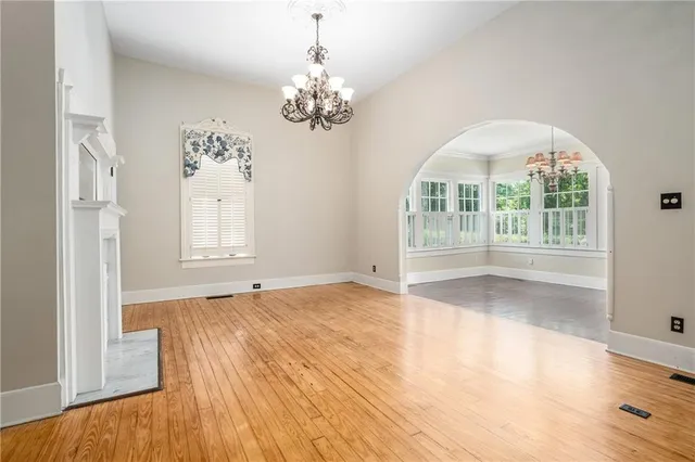 a view of a hallway with wooden floor and chandelier