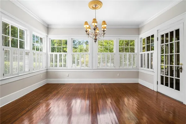 a view of an empty room with wooden floor fireplace and a window