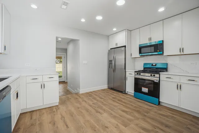 a kitchen with stainless steel appliances granite countertop a refrigerator stove and sink
