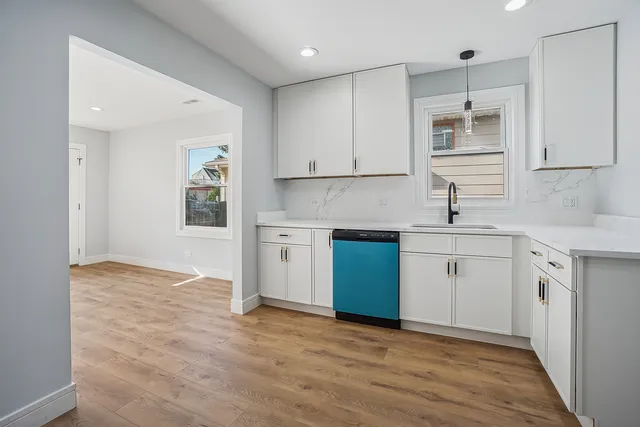 a kitchen with a sink cabinets and wooden floor