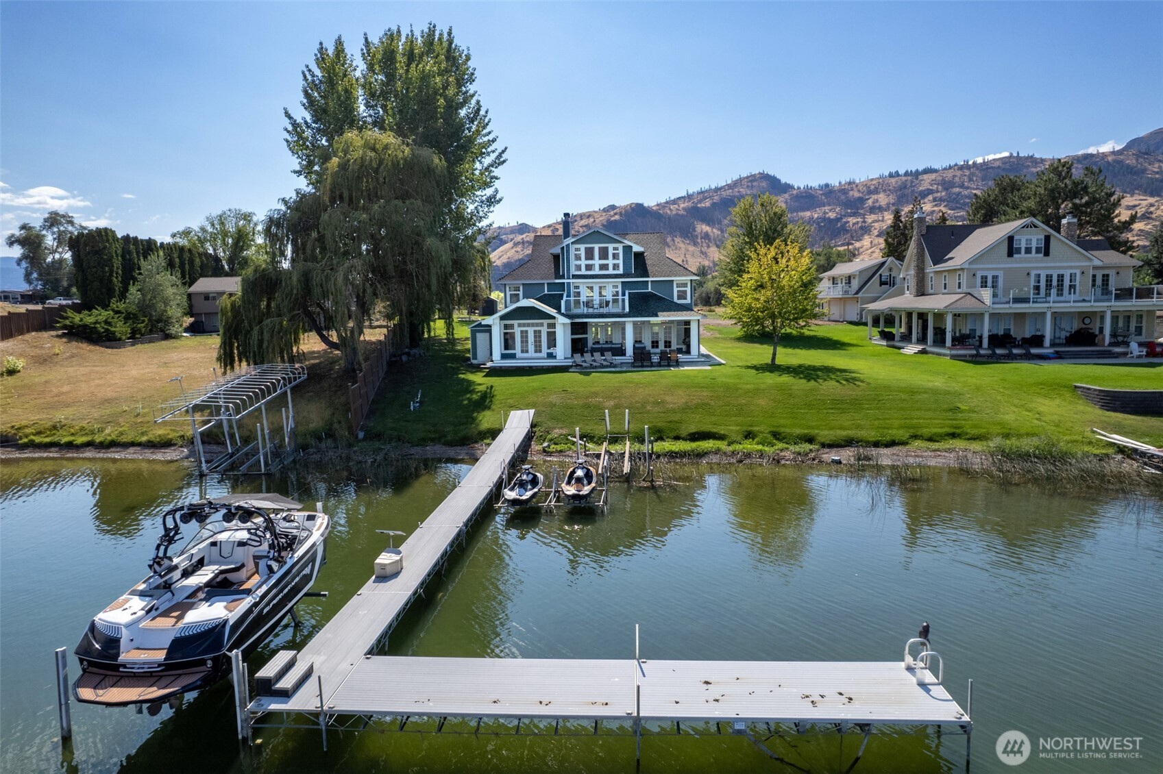 72 Boundary Point Road Oroville, WA 98844 - Photo 37 of 40 a view of a lake with a house in the background