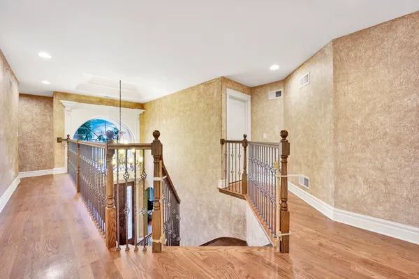 a view of a hallway with wooden floor and stairs