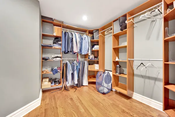 a view of walk in closet with clothes and shoes