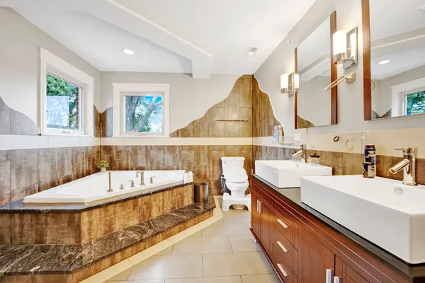 a bathroom with a tub a sink and a window
