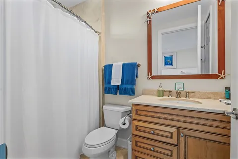 a bathroom with a sink a toilet a mirror and shower curtain