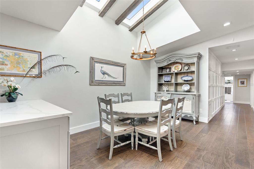 640 Arjay Way Winter Park, FL 32789 - Photo 11 of 46 a dining room with wooden floor a chandelier a wooden table and chairs