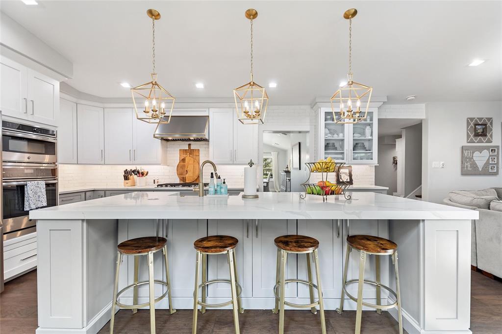 640 Arjay Way Winter Park, FL 32789 - Photo 12 of 46 a kitchen with stainless steel appliances kitchen island granite countertop a table chairs in it and wooden floors