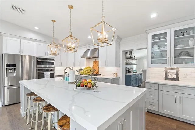 a kitchen with a sink a counter space appliances and cabinets