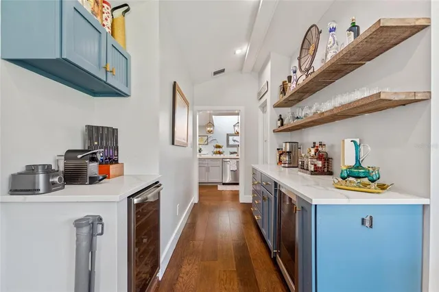 a kitchen that has a lot of cabinets and wooden floor