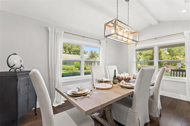 a dining room with furniture a chandelier and wooden floor
