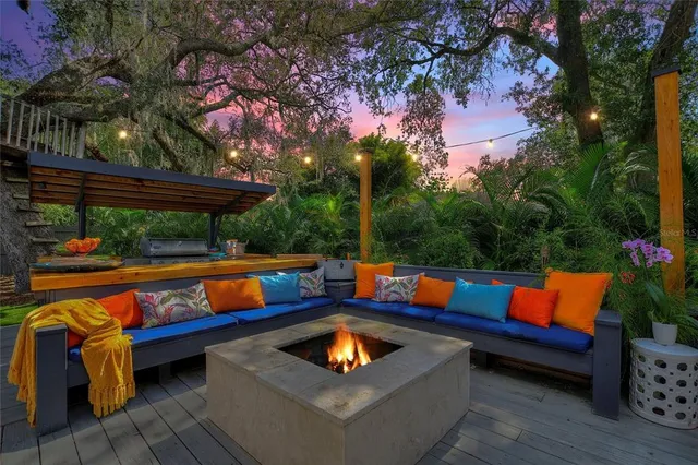 a blue swimming pool with outdoor seating and wooden fence
