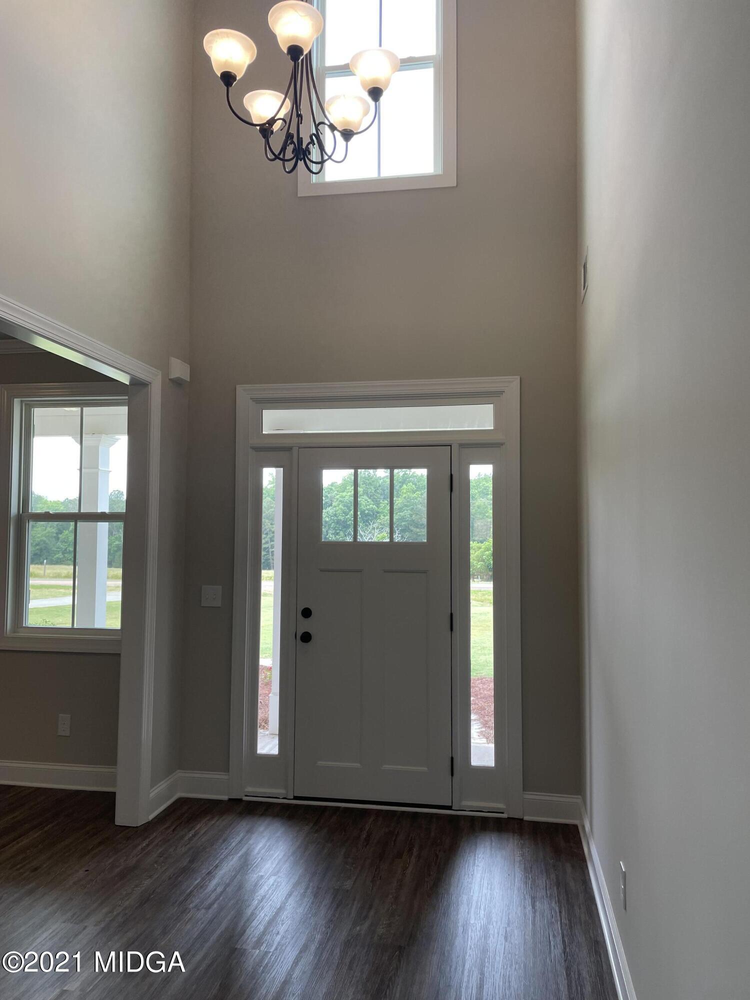 1256 Bunn Road Forsyth, GA 31029 - Photo 3 of 12 an empty room with wooden floor and windows