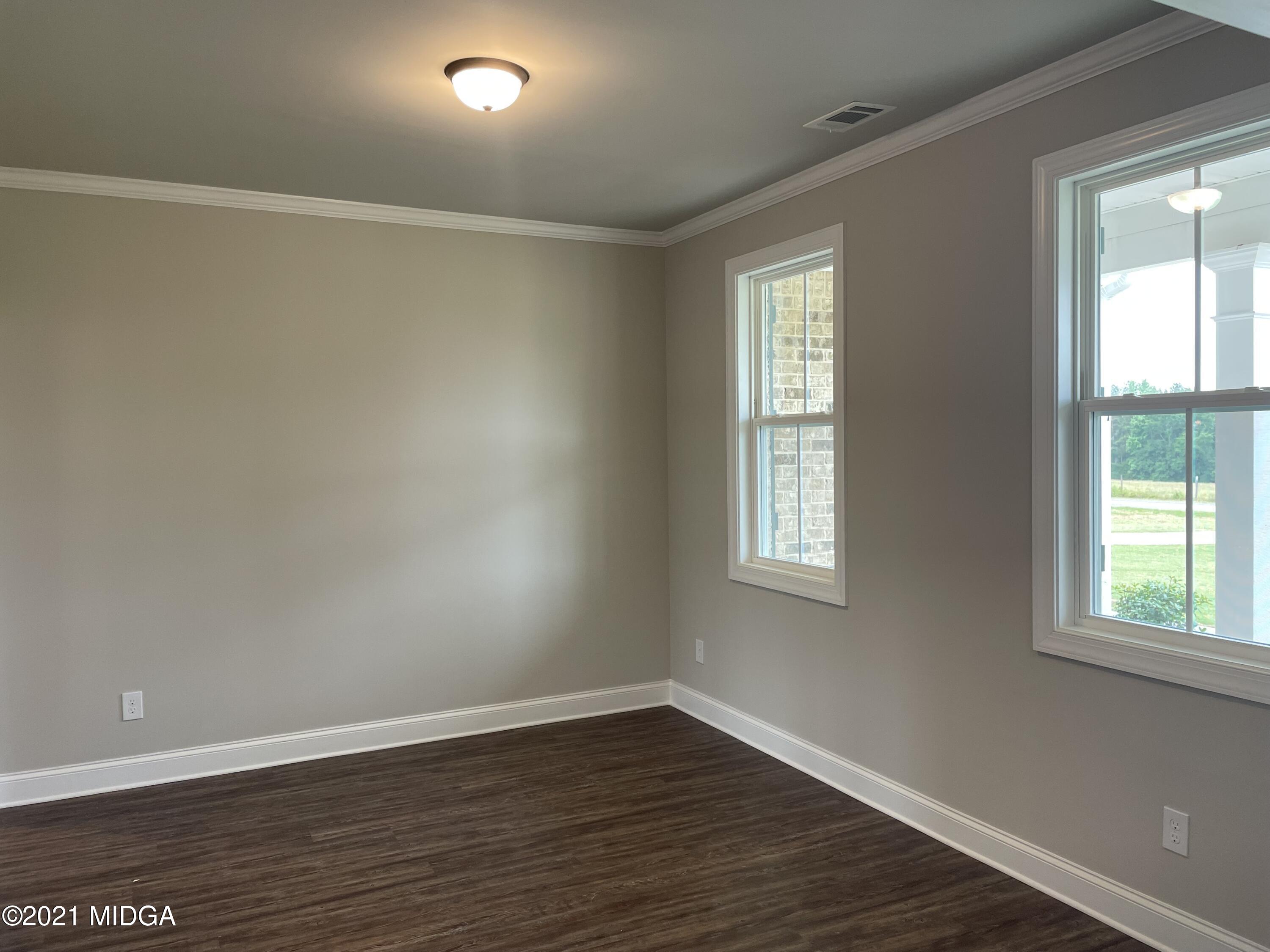1256 Bunn Road Forsyth, GA 31029 - Photo 4 of 12 an empty room with wooden floor and windows