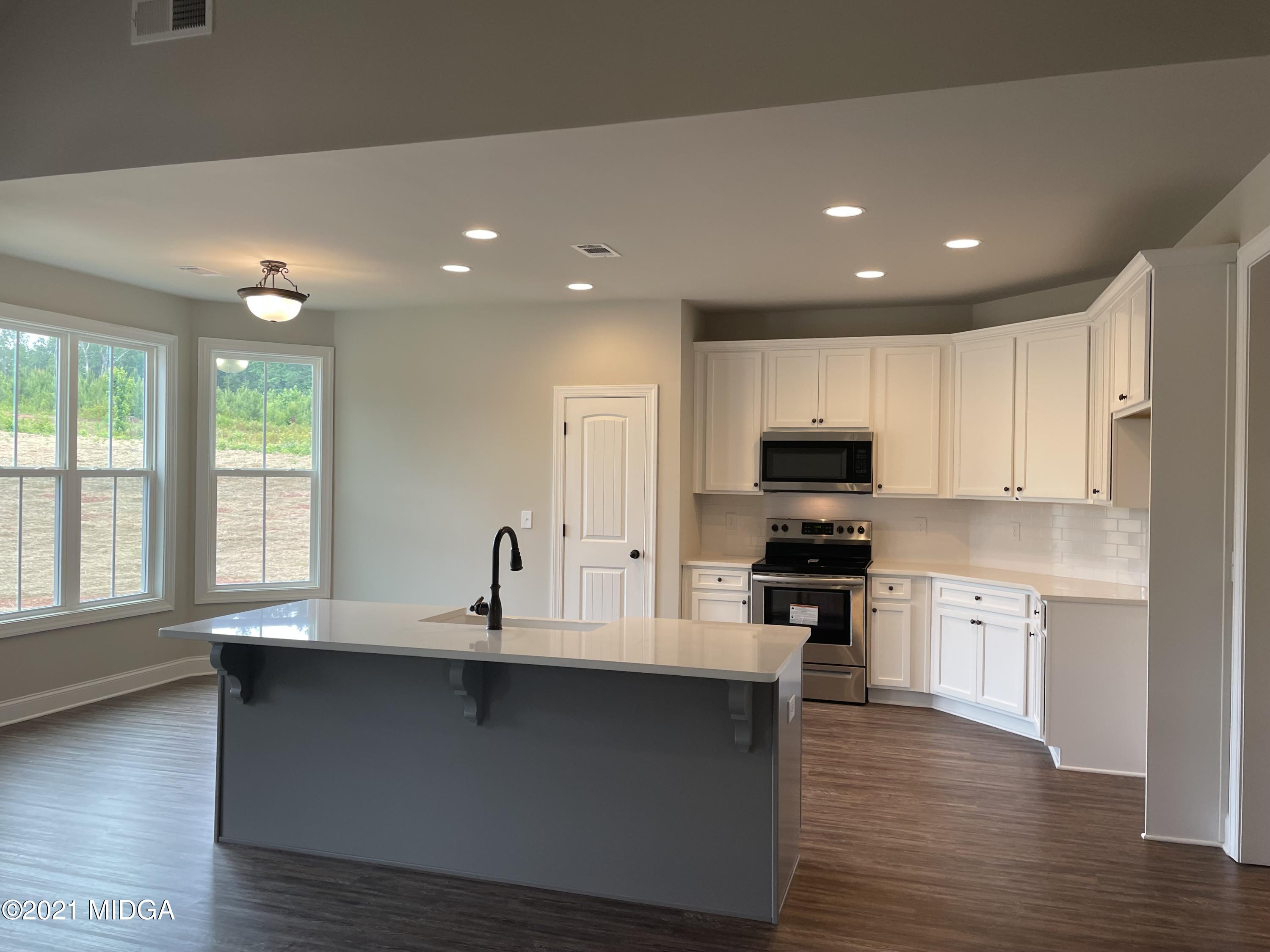 1256 Bunn Road Forsyth, GA 31029 - Photo 6 of 12 a kitchen with stainless steel appliances granite countertop a sink a stove and a wooden floors